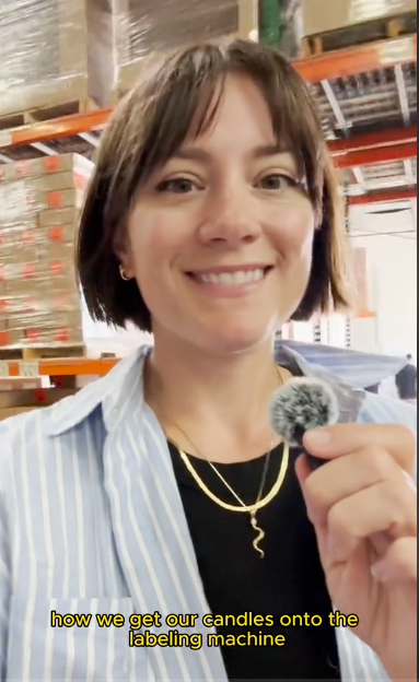 A woman with a joyful expression holds a small toy in her hand, showcasing her interest.